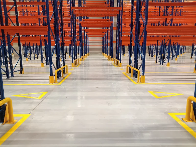 Aleja regałowa w centrum logistycznym z oznakowaniem poziomym